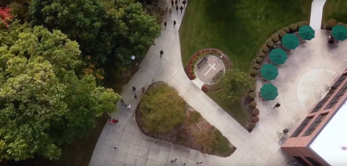 Image of Huntington University campus showing students walking along paths. 