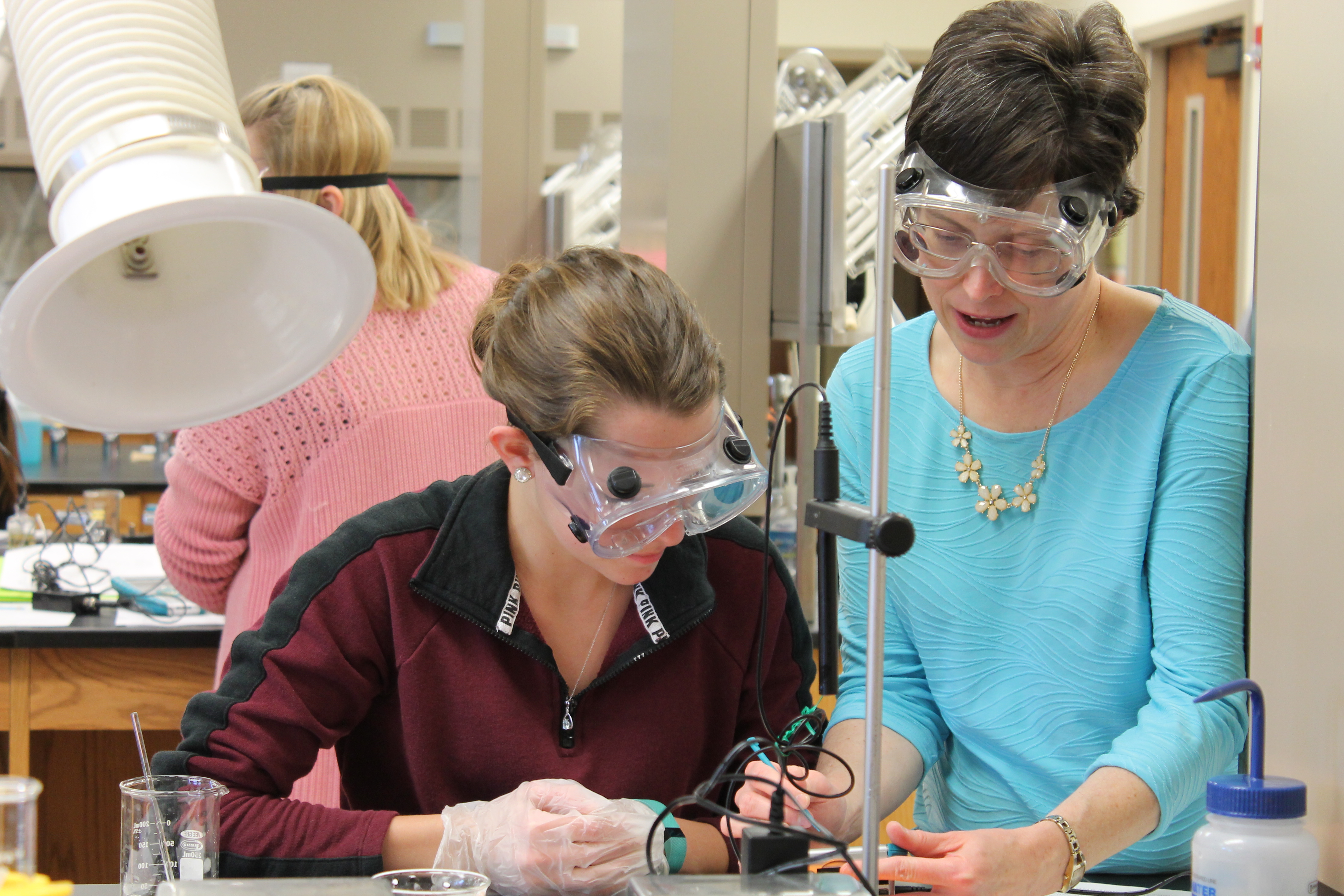 A chemistry instructor helps a student with an experiment.