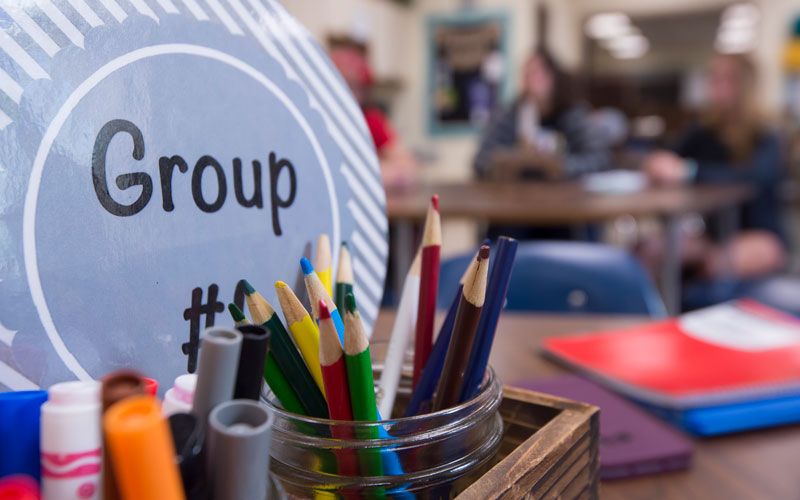 A close-up picture of a cup with pencils.