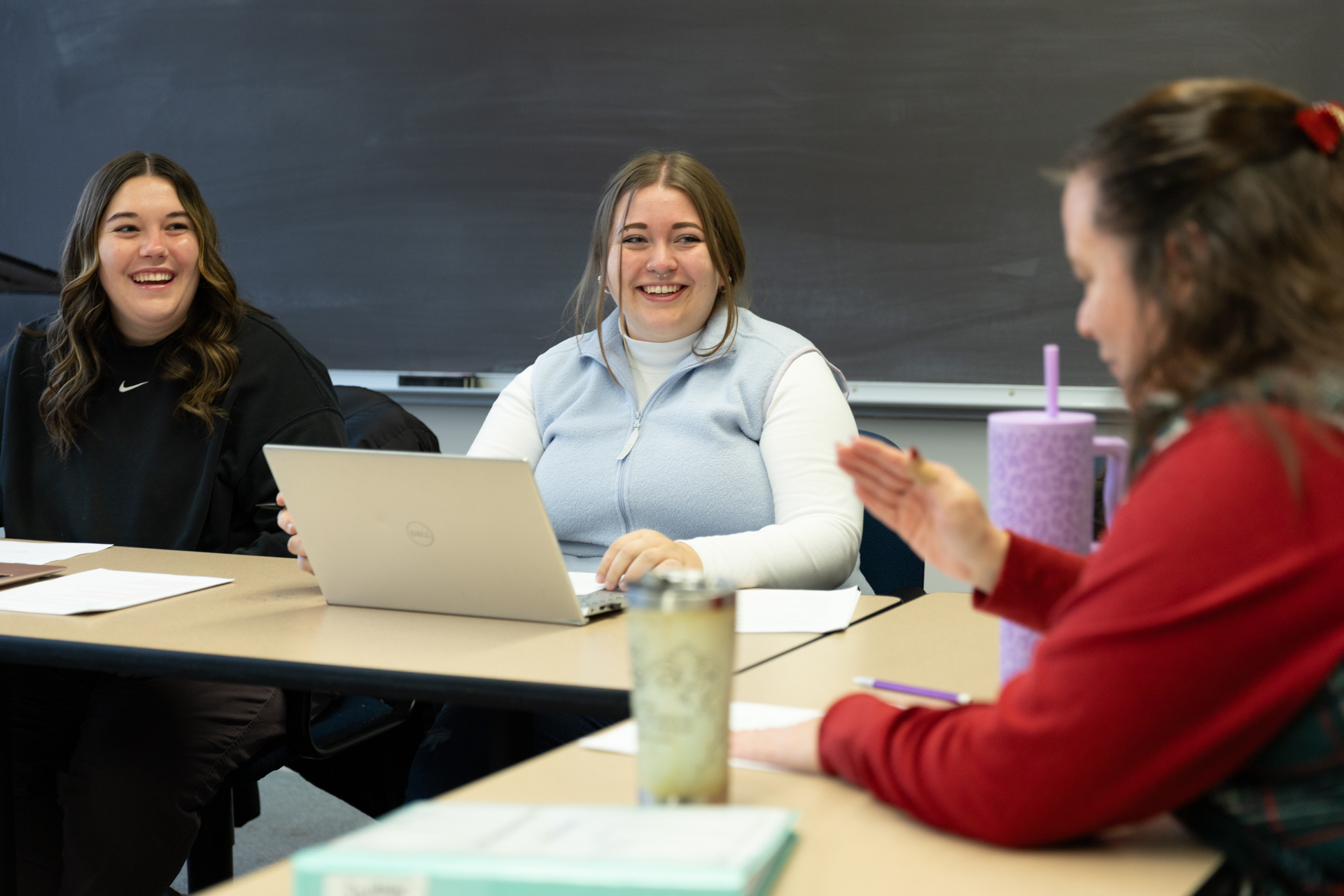 Two students smiling at the their instructor