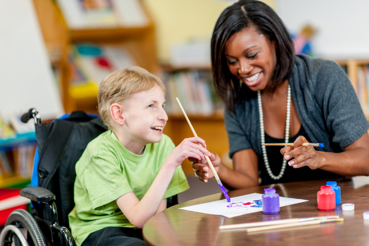 Professor helping special needs kid.